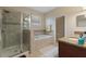 Well-lit bathroom featuring a glass-enclosed shower, soaking tub, and double sink vanity at 1353 Palmetto Dunes St, Davenport, FL 33836