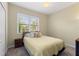 Cozy bedroom with a queen-sized bed, neutral decor, and a window providing natural light at 1353 Palmetto Dunes St, Davenport, FL 33836