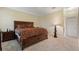 Spacious bedroom featuring a large bed with patterned bedding, a nightstand, and plush carpeting at 1353 Palmetto Dunes St, Davenport, FL 33836