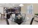 Stylish dining area featuring dark cabinetry, pendant lights, and a glass table at 1353 Palmetto Dunes St, Davenport, FL 33836