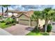 Beautiful home with a tile roof, two-car garage, brick driveway, and mature landscaping at 1353 Palmetto Dunes St, Davenport, FL 33836