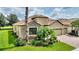 A home with a tile roof, two-car garage, brick driveway, and manicured landscaping at 1353 Palmetto Dunes St, Davenport, FL 33836
