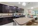 Modern kitchen with dark cabinetry, granite countertops, stainless steel appliances and island with bar seating at 1353 Palmetto Dunes St, Davenport, FL 33836