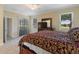 Comfortable main bedroom showcasing a large bed, dresser with a TV, and view of the green golf course at 1353 Palmetto Dunes St, Davenport, FL 33836