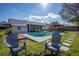 Backyard features a cozy firepit area, wood deck, outdoor dining under pergola, and in-ground swimming pool at 1375 Springfield St, Kissimmee, FL 34744