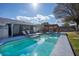 Inviting backyard pool with lounge chairs, outdoor dining under pergola, and well-maintained landscaping at 1375 Springfield St, Kissimmee, FL 34744