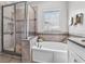 Elegant bathroom boasts tiled shower, soaking tub, double vanity, and modern fixtures at 1379 Kiawah St, Celebration, FL 34747