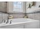 Close up of the elegant soaking tub with modern fixtures and a tiled wall and accent at 1379 Kiawah St, Celebration, FL 34747
