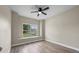 A bright bedroom with light wood floors, neutral walls, a window, and a ceiling fan at 14639 Musket Fire Ln, Orlando, FL 32837