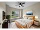 Serene bedroom with natural light, a large window view, a ceiling fan, and contemporary furniture at 14639 Musket Fire Ln, Orlando, FL 32837