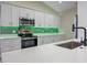 Bright kitchen featuring white cabinets, stainless steel appliances, quartz countertops, and a sleek, modern design at 14639 Musket Fire Ln, Orlando, FL 32837