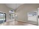Bright living room featuring light wood floors, a vaulted ceiling, large windows, and a sliding glass door to the pool area at 14639 Musket Fire Ln, Orlando, FL 32837