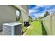 Backyard featuring potted plants, an air conditioner, green grass, and white fence at 148 Whirlaway Dr, Davenport, FL 33837