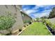 Green backyard featuring a mulched landscape bed, retaining wall, and well-maintained grass at 148 Whirlaway Dr, Davenport, FL 33837