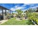 A cozy yard with tropical plants, framed by a fence and a screened enclosure at 148 Whirlaway Dr, Davenport, FL 33837