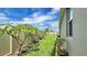 View of the side yard and landscaping, with tropical plants and manicured lawn at 148 Whirlaway Dr, Davenport, FL 33837