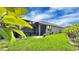 Lush backyard featuring a screened-in lanai, green grass, and tropical landscaping at 148 Whirlaway Dr, Davenport, FL 33837
