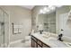 Well-lit bathroom features a double vanity, granite countertop, walk-in shower with glass door and marble floors at 148 Whirlaway Dr, Davenport, FL 33837