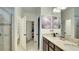 Modern bathroom featuring a granite vanity top, dual sinks, walk-in shower, and direct access to a walk-in closet at 148 Whirlaway Dr, Davenport, FL 33837