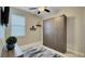 Neutral bedroom featuring a murphy bed, textured wallpaper, ceiling fan, and floating shelves at 148 Whirlaway Dr, Davenport, FL 33837
