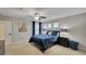 This bedroom showcases a king bed with navy bedding, two side tables with lamps, carpet flooring, and a serene ambiance at 148 Whirlaway Dr, Davenport, FL 33837