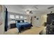 This bedroom features a king-sized bed, carpet flooring, access to a closet and bathroom, three windows, and modern decor at 148 Whirlaway Dr, Davenport, FL 33837