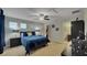 A cozy bedroom features a ceiling fan, two windows, and a king-size bed with blue comforter and access to bathroom and walk-in closet at 148 Whirlaway Dr, Davenport, FL 33837