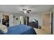Bedroom features a blue comforter, a ceiling fan, an entertainment center, a walk-in closet and an ensuite bathroom at 148 Whirlaway Dr, Davenport, FL 33837