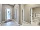 Hallway features a white front door, tile flooring, and a view into the bathroom with a glass enclosed shower at 148 Whirlaway Dr, Davenport, FL 33837