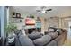 Spacious living room featuring a comfortable sectional sofa, decorative shelves, and a ceiling fan at 148 Whirlaway Dr, Davenport, FL 33837