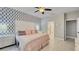 Well-lit main bedroom with modern wallpaper, tiled floors, and en-suite bathroom access at 148 Whirlaway Dr, Davenport, FL 33837