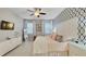 Comfortable main bedroom with patterned accent wall, white furniture, and window views at 148 Whirlaway Dr, Davenport, FL 33837