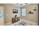 Home office with tile floors, a small console table, mounted TV, and a window for natural light at 148 Whirlaway Dr, Davenport, FL 33837