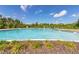 Large community pool surrounded by trees, plantings, and lounge seating at 148 Whirlaway Dr, Davenport, FL 33837
