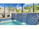Relaxing pool water feature and blue tile accents, creating a serene backyard oasis with a privacy wall at 148 Whirlaway Dr, Davenport, FL 33837