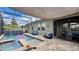 Screened-in pool and spa with waterfall feature and covered patio lounge area at 148 Whirlaway Dr, Davenport, FL 33837