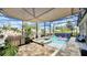 Inviting covered pool area with a built-in spa, outdoor kitchen, and tiled patio, perfect for entertaining at 148 Whirlaway Dr, Davenport, FL 33837