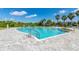 Beautiful community pool with lounge seating, palm trees, and paved pool deck at 148 Whirlaway Dr, Davenport, FL 33837