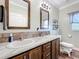 Bathroom featuring double sinks, wood cabinets, and decorative mirrors at 15311 Johns Lake Rd, Clermont, FL 34711