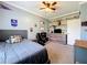Comfortable bedroom with fan, wood-accent wall, and gaming setup at 15311 Johns Lake Rd, Clermont, FL 34711