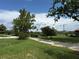 Lovely front yard with mature trees, blooming bushes, and a long winding driveway at 15311 Johns Lake Rd, Clermont, FL 34711