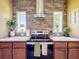 Modern kitchen with stainless steel range hood and cooktop, flanked by bright windows at 15311 Johns Lake Rd, Clermont, FL 34711