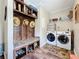 Spacious laundry area featuring a washer, dryer, custom storage, bench, and wood-look floors at 15311 Johns Lake Rd, Clermont, FL 34711