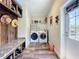 Well-organized laundry room with washer, dryer, wood-look floors, and custom built-in storage at 15311 Johns Lake Rd, Clermont, FL 34711