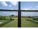 Golf course backyard view through a large window, overlooking a well-maintained lawn and landscaping at 15600 Vetta Dr, Bella Collina, FL 34756