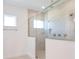 Bright bathroom with a tiled shower, glass door and a window bringing natural light at 15600 Vetta Dr, Bella Collina, FL 34756