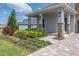 Charming front yard with lush landscaping, a brick pathway, and a covered porch at 15600 Vetta Dr, Bella Collina, FL 34756