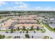 Expansive aerial view showcasing a neighborhood of townhouses with manicured landscaping and community amenities under blue skies at 1565 Plunker Dr, Davenport, FL 33896