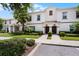 Well-maintained townhomes with red roofs, lush landscaping, and charming architectural details under a sunny sky at 1565 Plunker Dr, Davenport, FL 33896