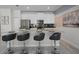 Modern kitchen island with bar stools and stainless steel appliances and white cabinets at 1565 Plunker Dr, Davenport, FL 33896